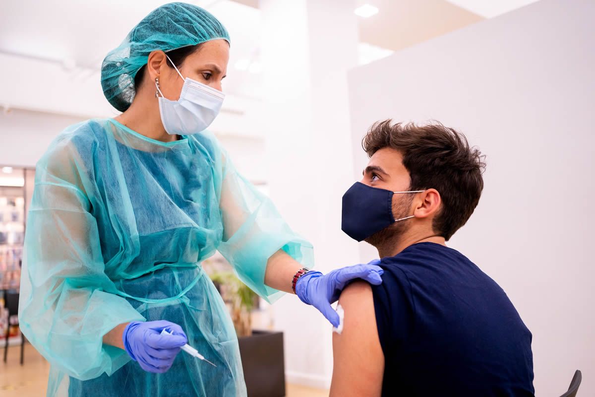Una farmacéutica vacuna a un colegiado del COFM en la campaña de vacunación 2021